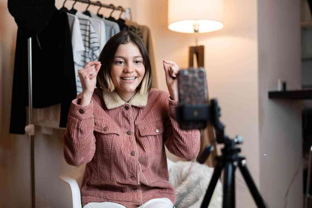 A person holding a camera in front of a table.