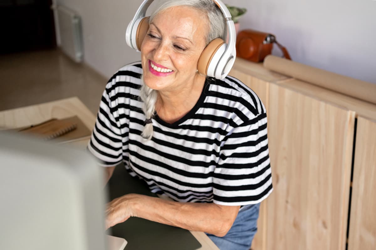 Female freelancer wearing headphones works at computer