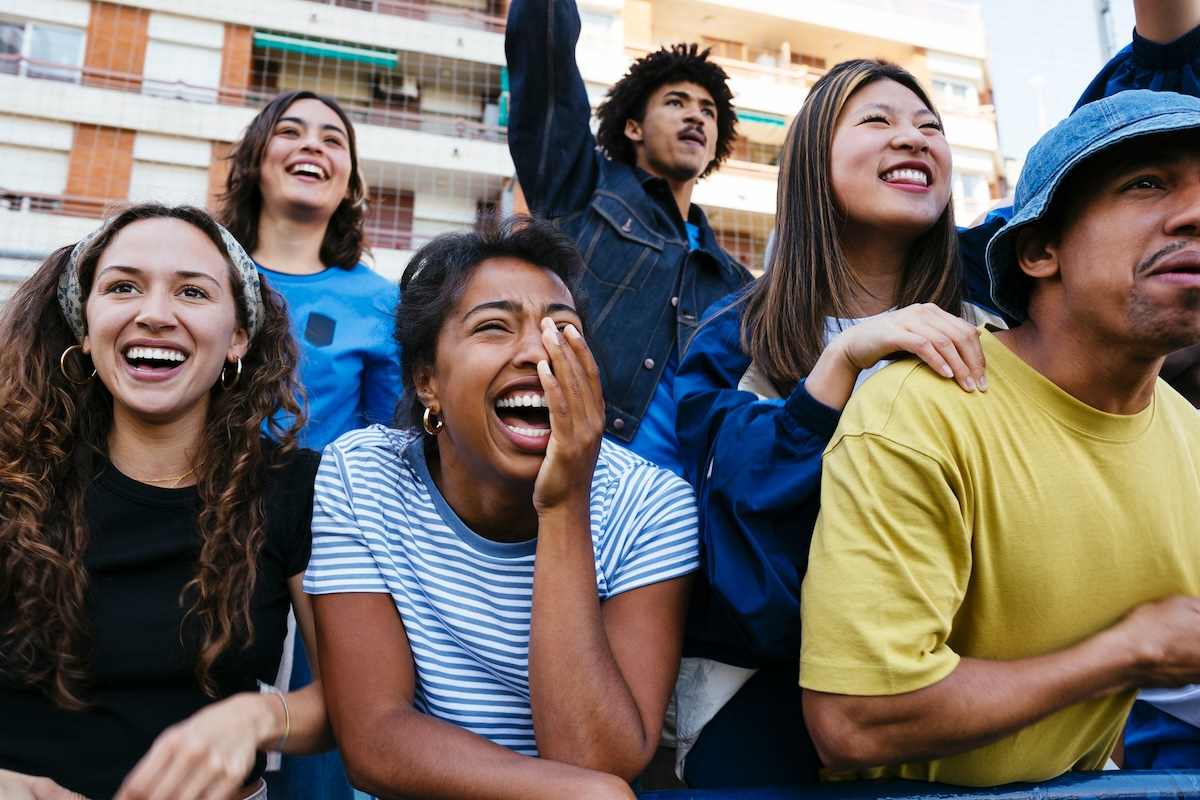 A group of people cheering at a sporting evemt.