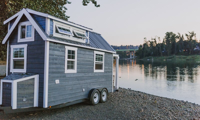 Tiny house on wheels next to a lake