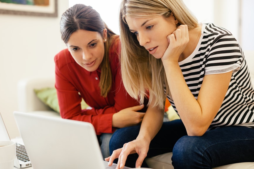 Two women using a laptop computer