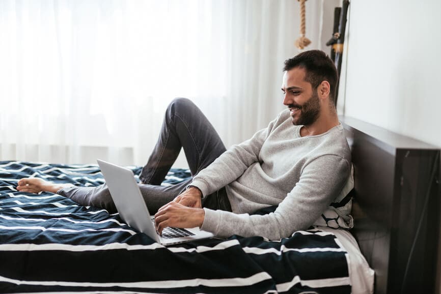 Self-employed man at home using his laptop to look for freelance work.