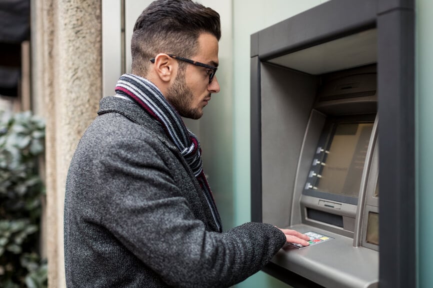 Man checking his account balance at an ATM.
