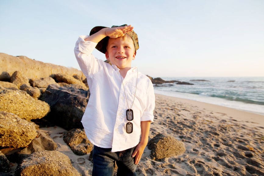 little boy on the beach saluting