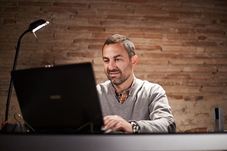 Worker on computer with lamp shining