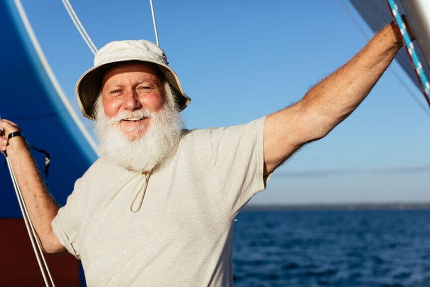 Happy man with a beard on a sailboat