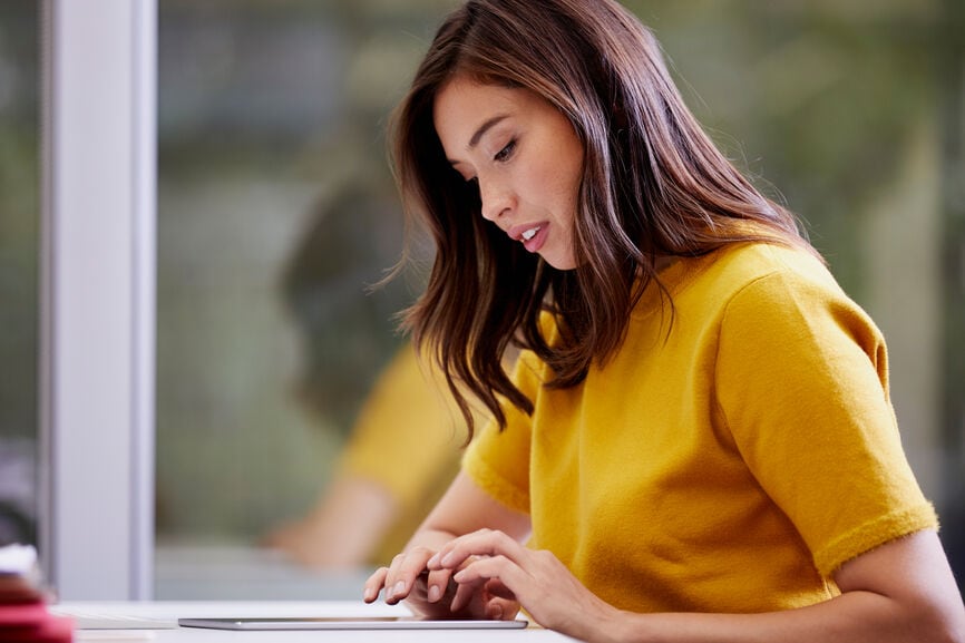 Serious businesswoman using digital tablet at desk in office