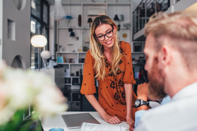 Smiling woman sitting on desk