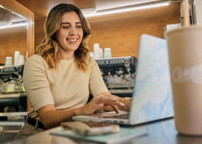 Una persona sentada en un escritorio con una laptop.