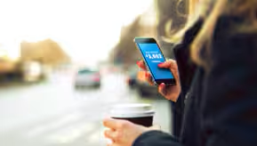 Una persona con un tel. celular en la mano.