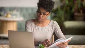 Una persona sentada en un escritorio con una laptop.