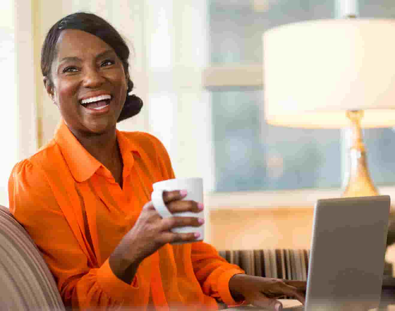 Cheerful older woman looking up from her laptop