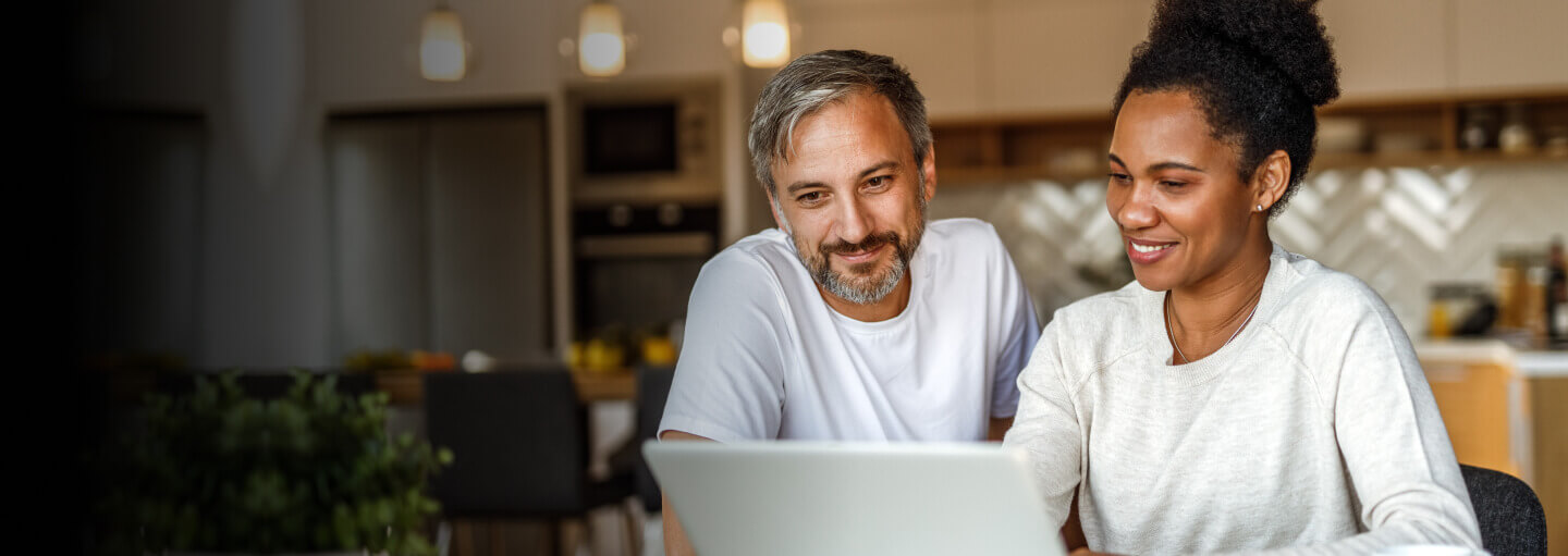 A person sitting at a table with a laptop computer.