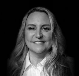 A person with a tie and a cup smiling.