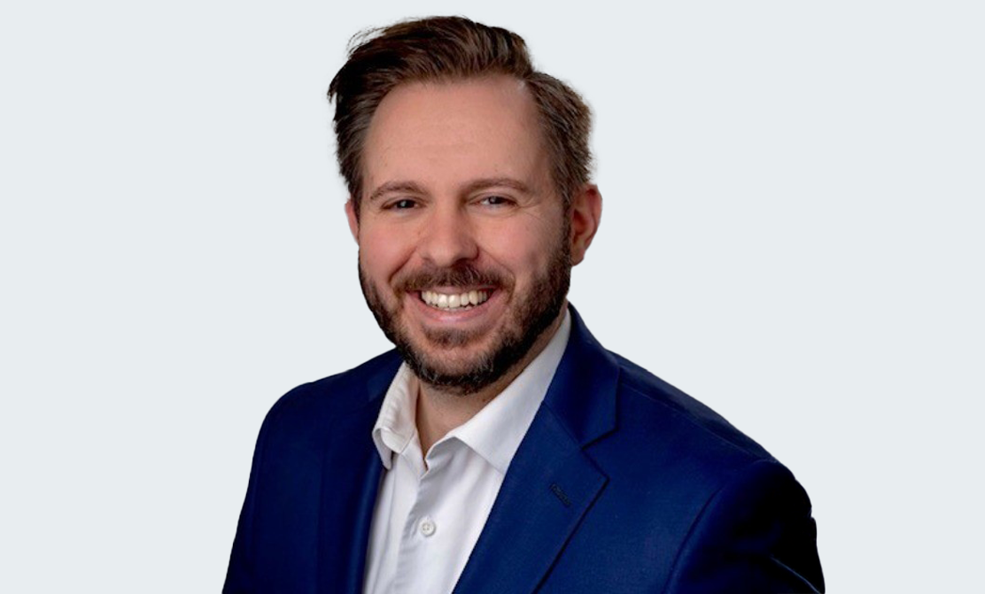 A person in a suit smiles while smiling.