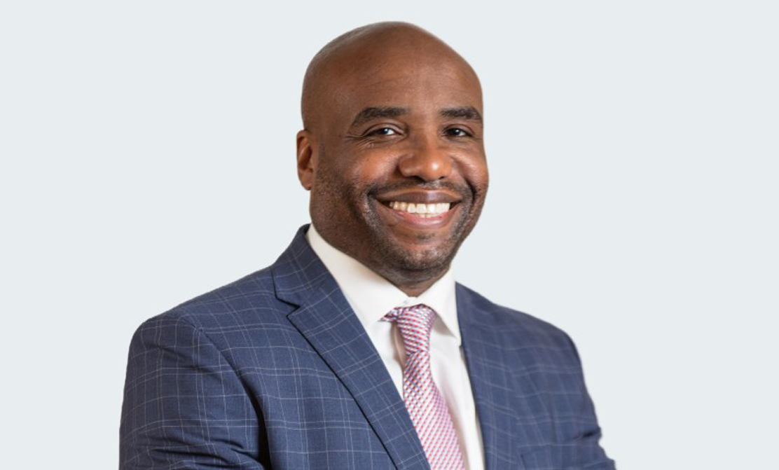 A person in a suit and tie smiles.