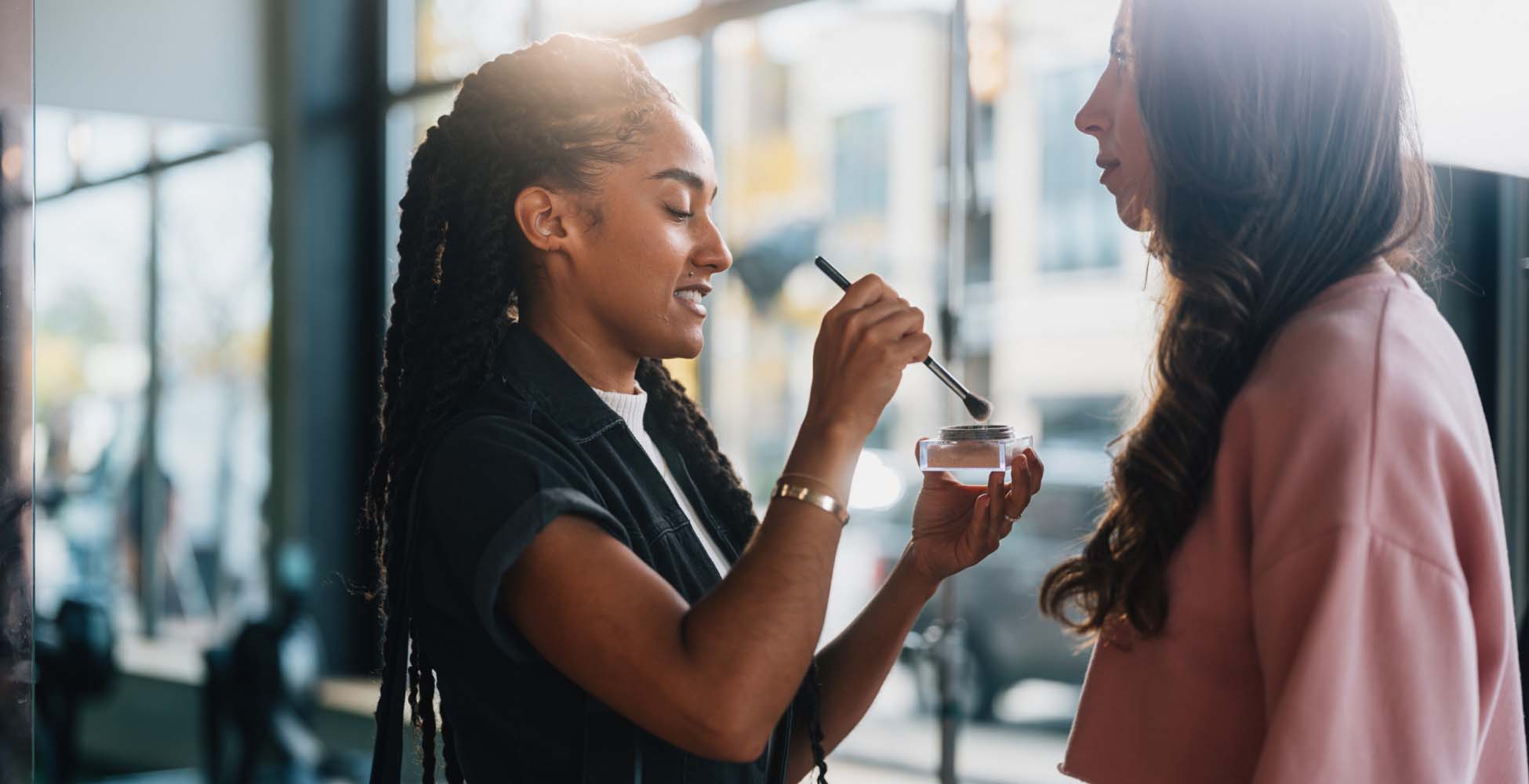 Female make-up artist doing make-up of female client