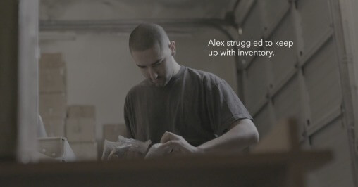 static video clip of a man working in a dimmed light environment with “Alex struggling to keep up with inventory” elegantly placed next to his head