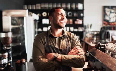 Smiling barista standing with arms crossed with hard lighting and unnatural saturation