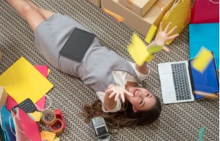 Conceptual stock photo of person laying on floor throwing paper in the air