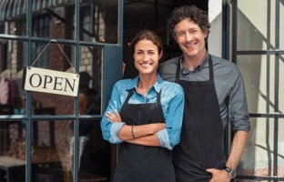 Generic stock photo of small business owners standing outside of glass door