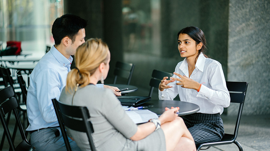 A group of people sitting around a table, young accountant interviewing for a job