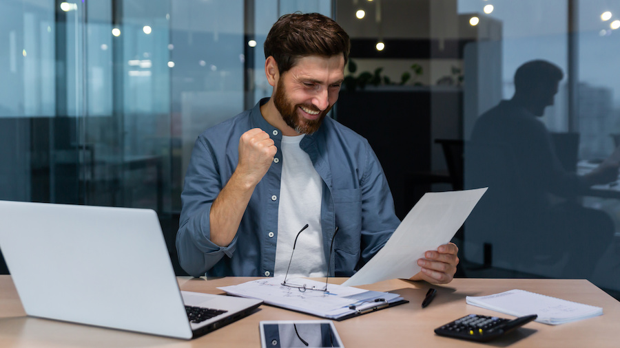 A person sitting at a desk with a laptop computer.