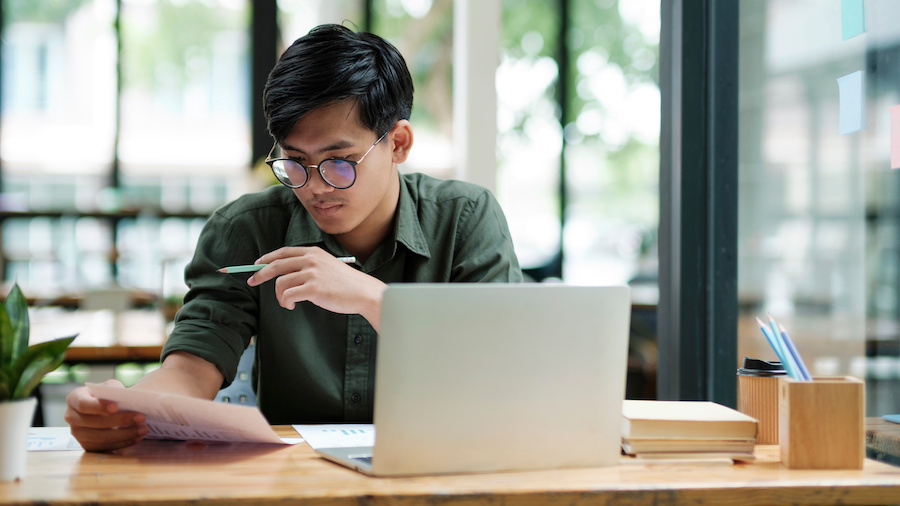 A person sitting at a table with a laptop computer.