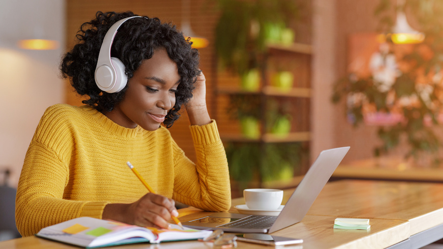 A person sitting at a desk with a laptop and headphones.