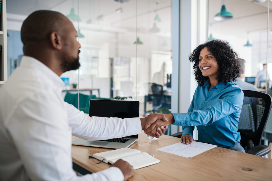 Two people shaking hands and forming a partnership.