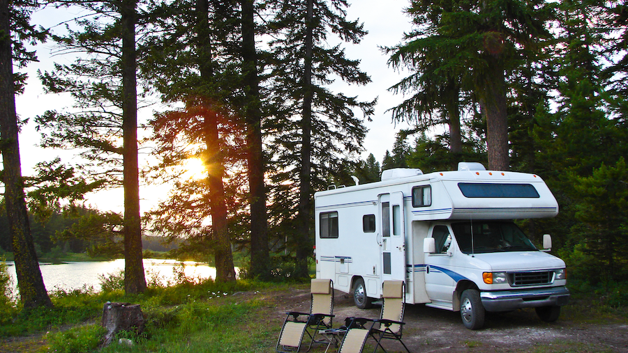 An RV parked by a lake.