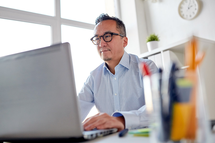 A person sitting at a desk with a laptop computer.