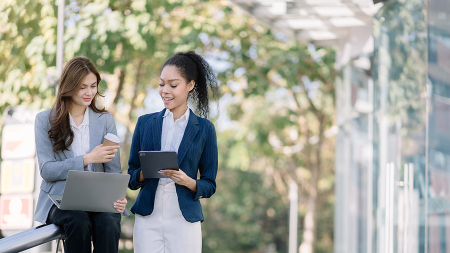 Two accountants discussing what's new in QuickBooks Online in front of a building.