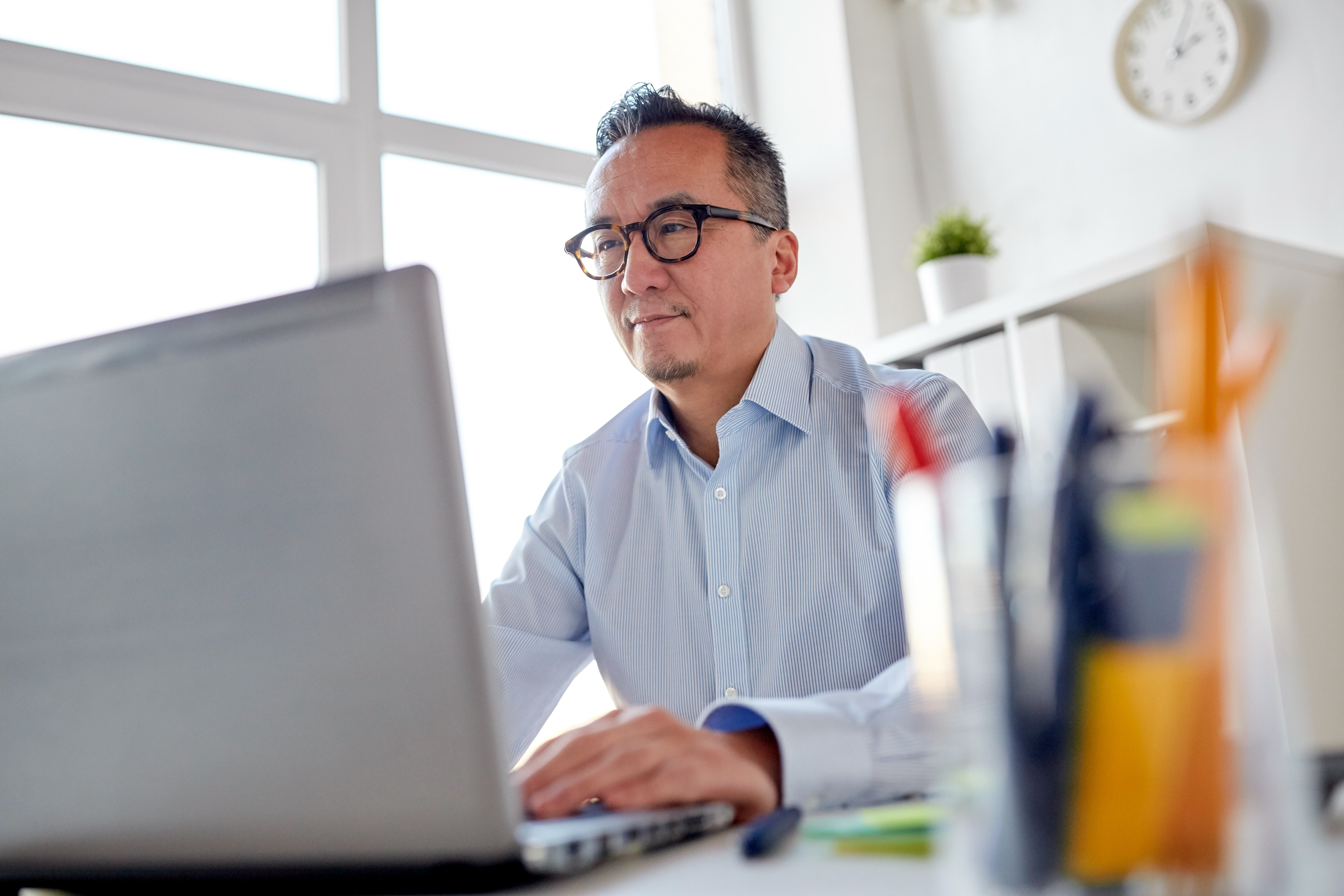 Businessman reviewing client advisory services on his laptop.