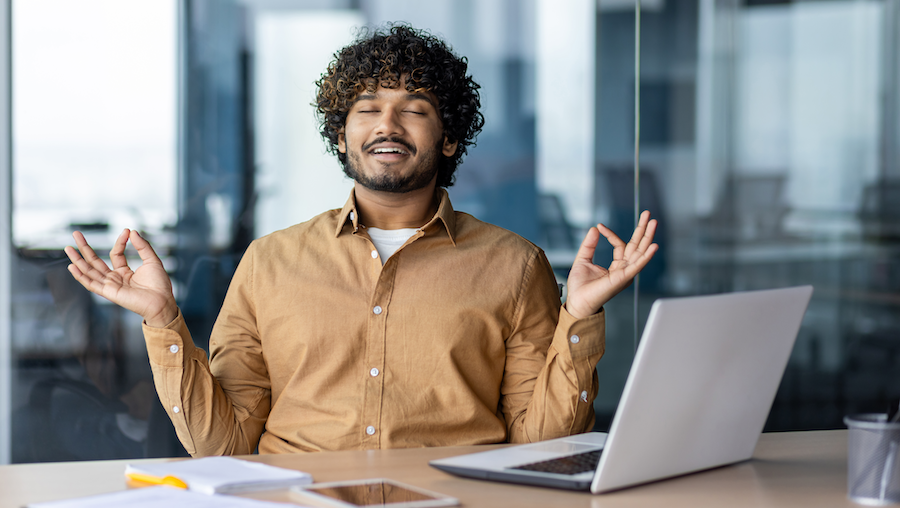 Businessman meditating at his desk.