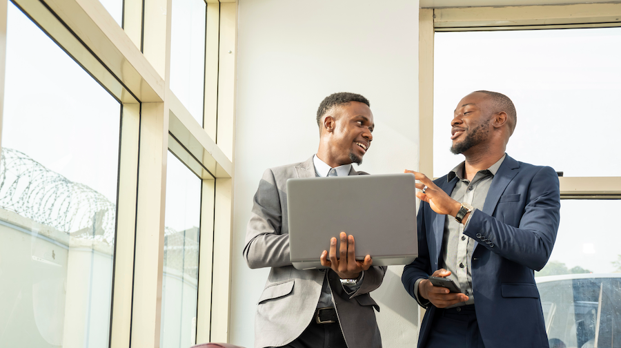 Two accountants discussing QuickBooks Online, using a laptop.