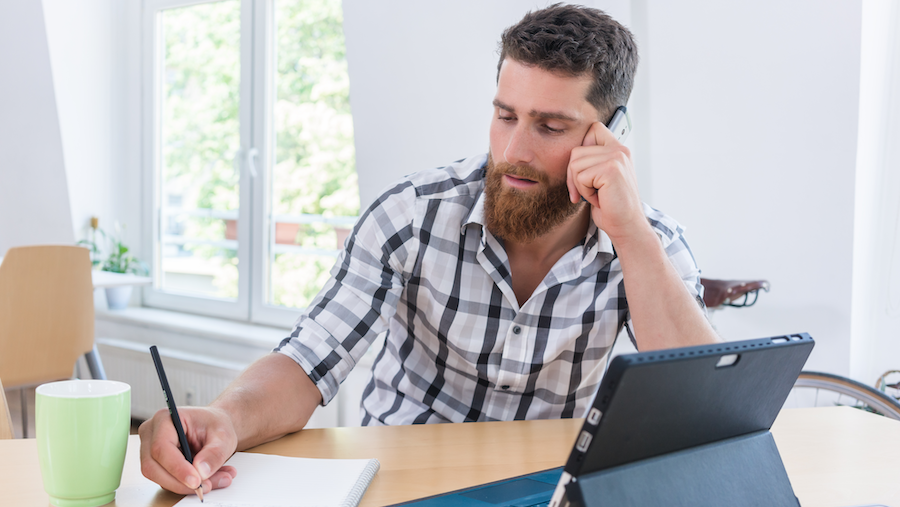 An independent contractor making a phone call and taking notes.