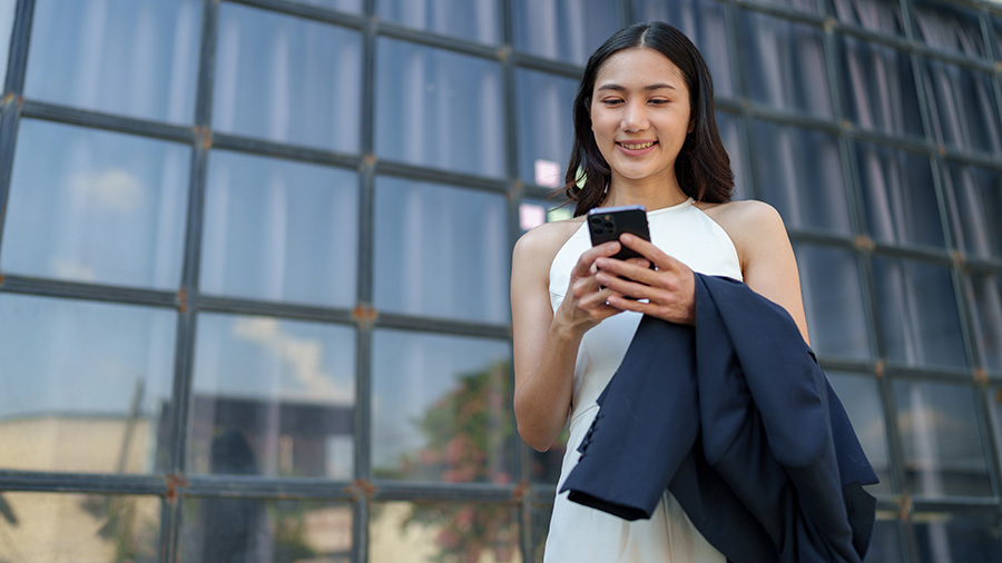 A person in a white dress holding a cell phone.