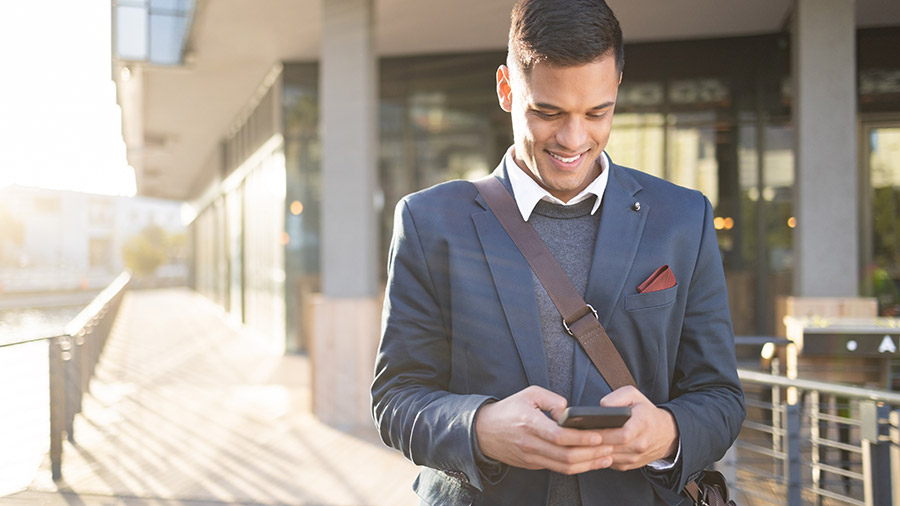 A person in a suit and tie holding a cell phone.