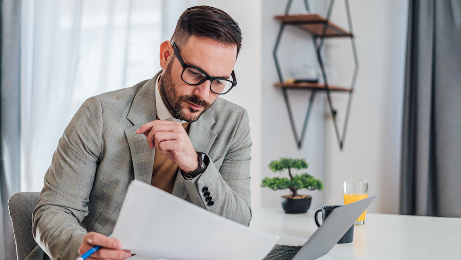 Accountant reviewing documents at his computer.