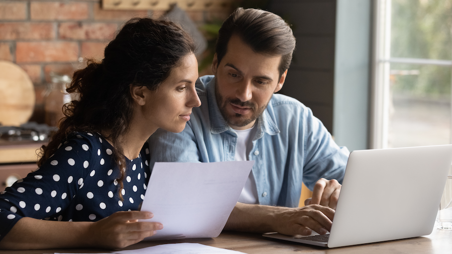 A couple reviewing their financials on a laptop.