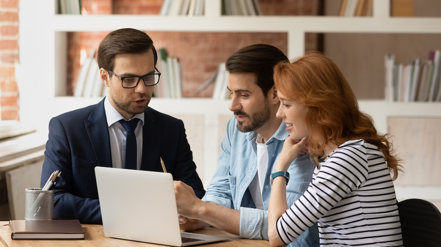 A trusted advisor guiding two business owners on their laptop.