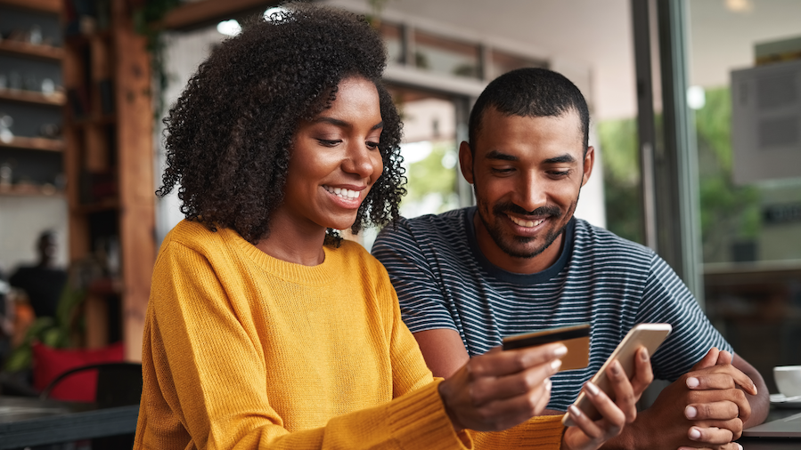 Two people looking at making a payment on their phone.