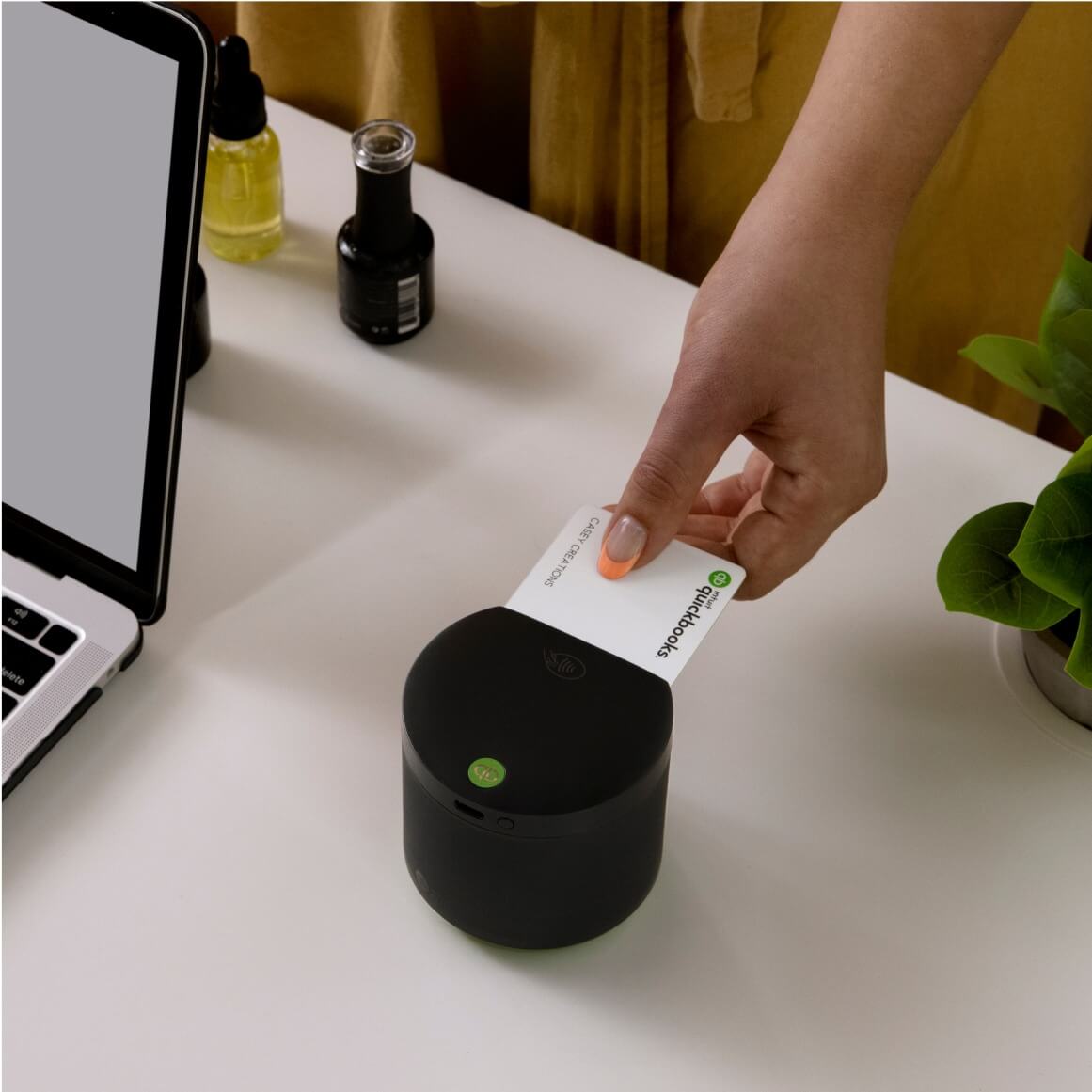 Woman using her QuickBooks Debit card to pay on a card reader