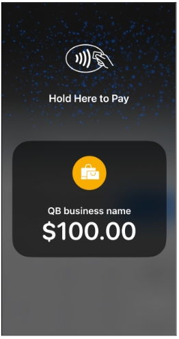 A person is holding a credit card in front of a bank.