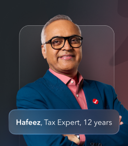 A middle-aged male TurboTax expert wearing a blue blazer and a red TurboTax pin.