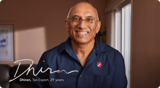 Dhiren, a TurboTax tax expert with 29 years of experience smiling brightly in his home office.