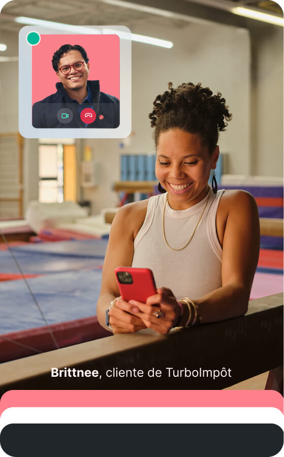A smiling small business owner in a gymnastics studio uses her smartphone to consult with a TurboTax expert via a live video call overlay.