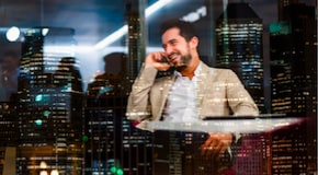 A person sitting in a chair talking on a phone. 