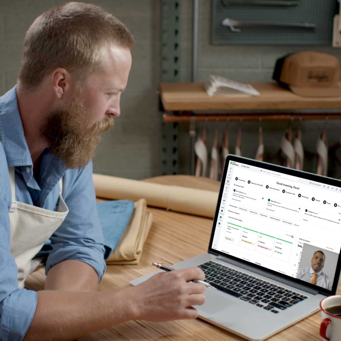A QuickBooks Live Expert Assisted customer is sitting in front of a laptop on a video chat with a bookkeeper.